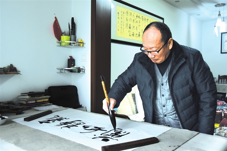 桌边摆放着各色毛笔,墨汁等书写工具,这就是李敢平时写书法的"小天地"