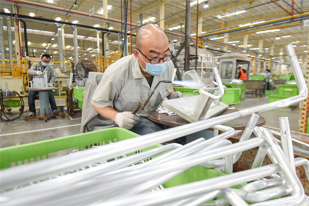 在湖北美標汽車製冷系統有限公司生產車間,工人在生產線上作業.