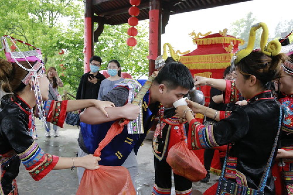 5月21日,游客在金丘村体验和观赏畲族特色婚嫁表演.