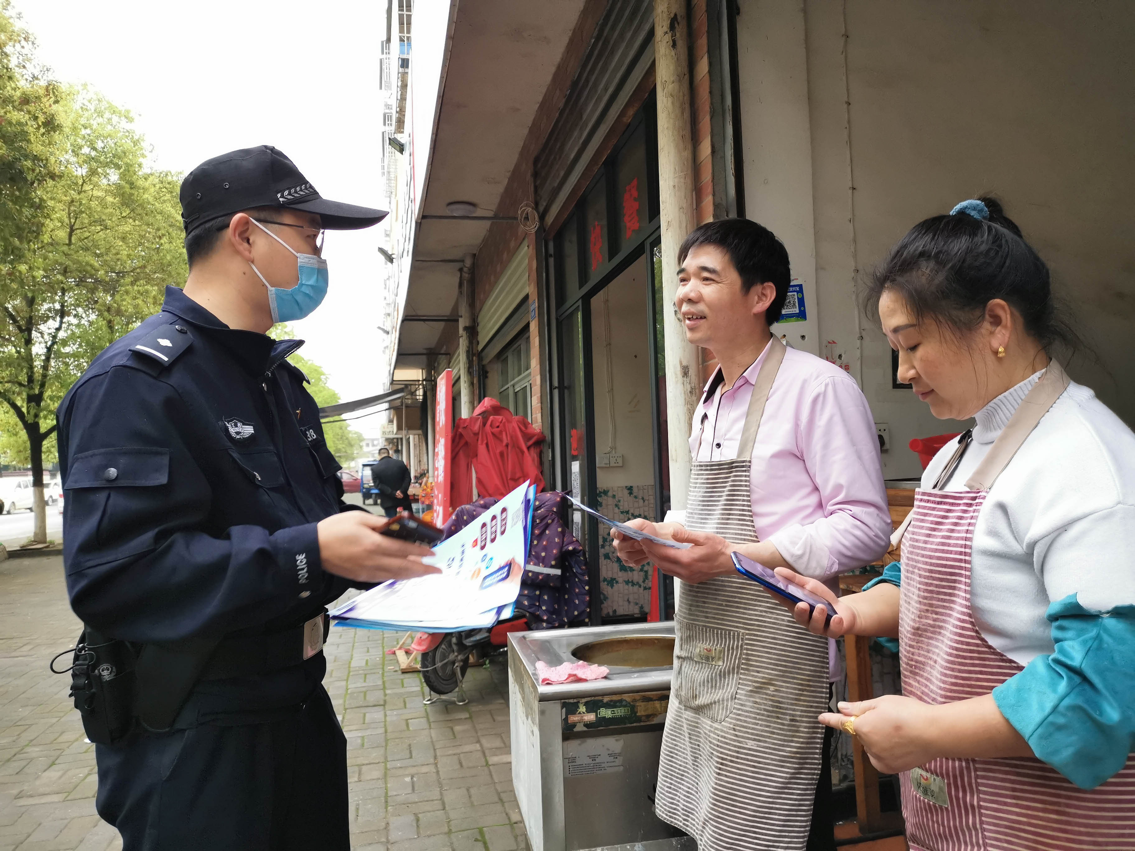 奉新县赤岸镇派出所民警在向居民宣传防电信诈骗知识。（夏文 摄）