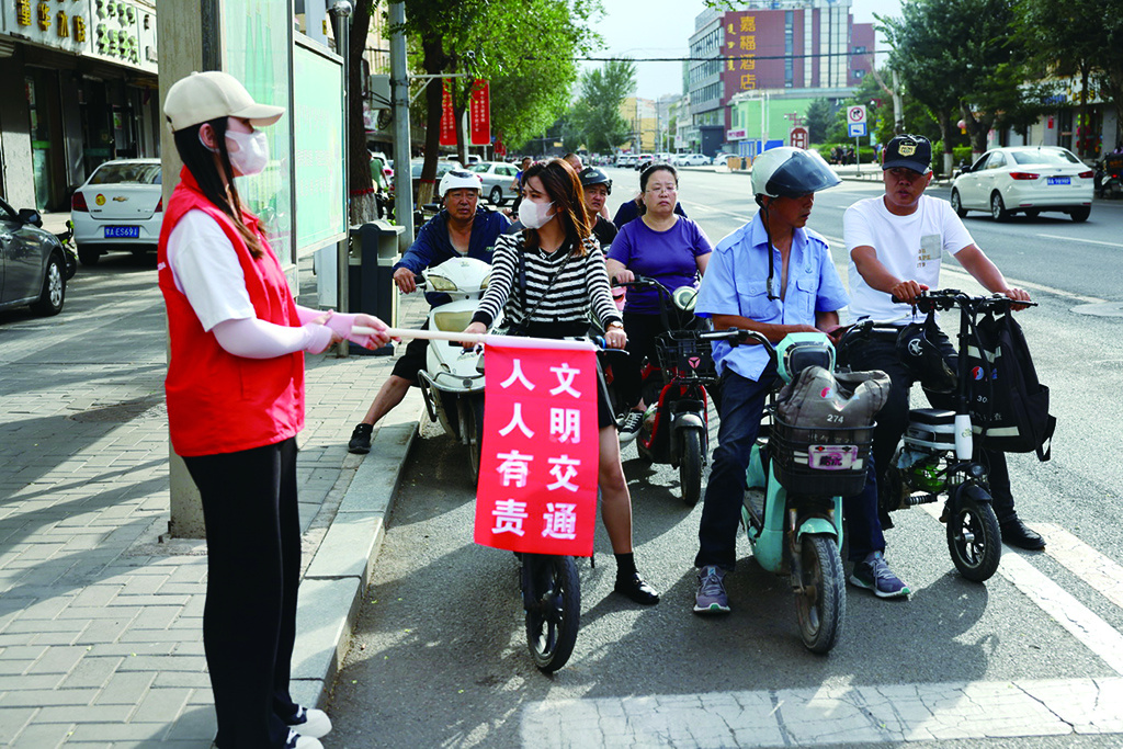 文明交通志愿者在开展文明交通引导。（摄影：孙岳龙）