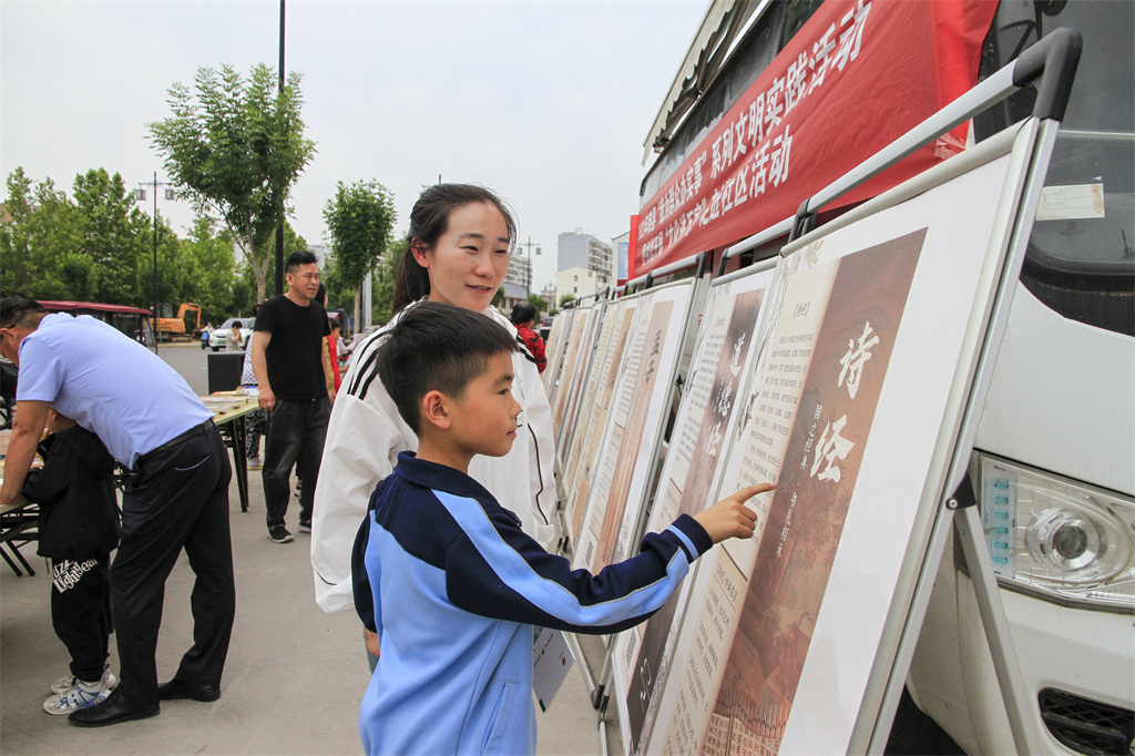 小读者和家长一起参观国学文化展板 徐泽源 摄