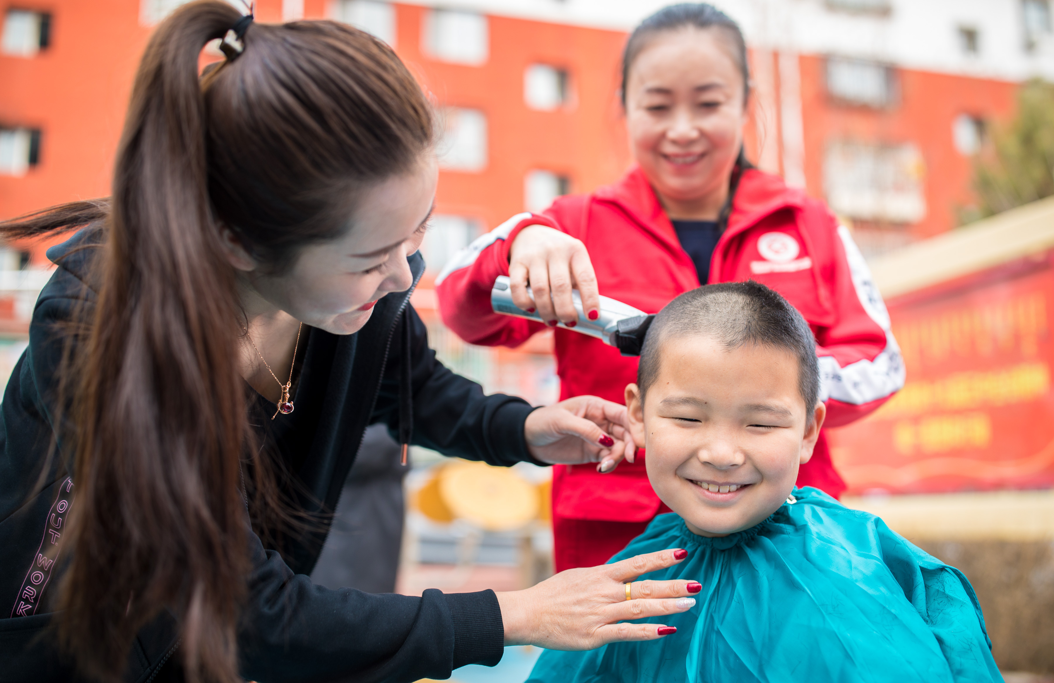 3月14日,内蒙古呼和浩特市玉泉区清泉街社区的志愿者在为小朋友理发