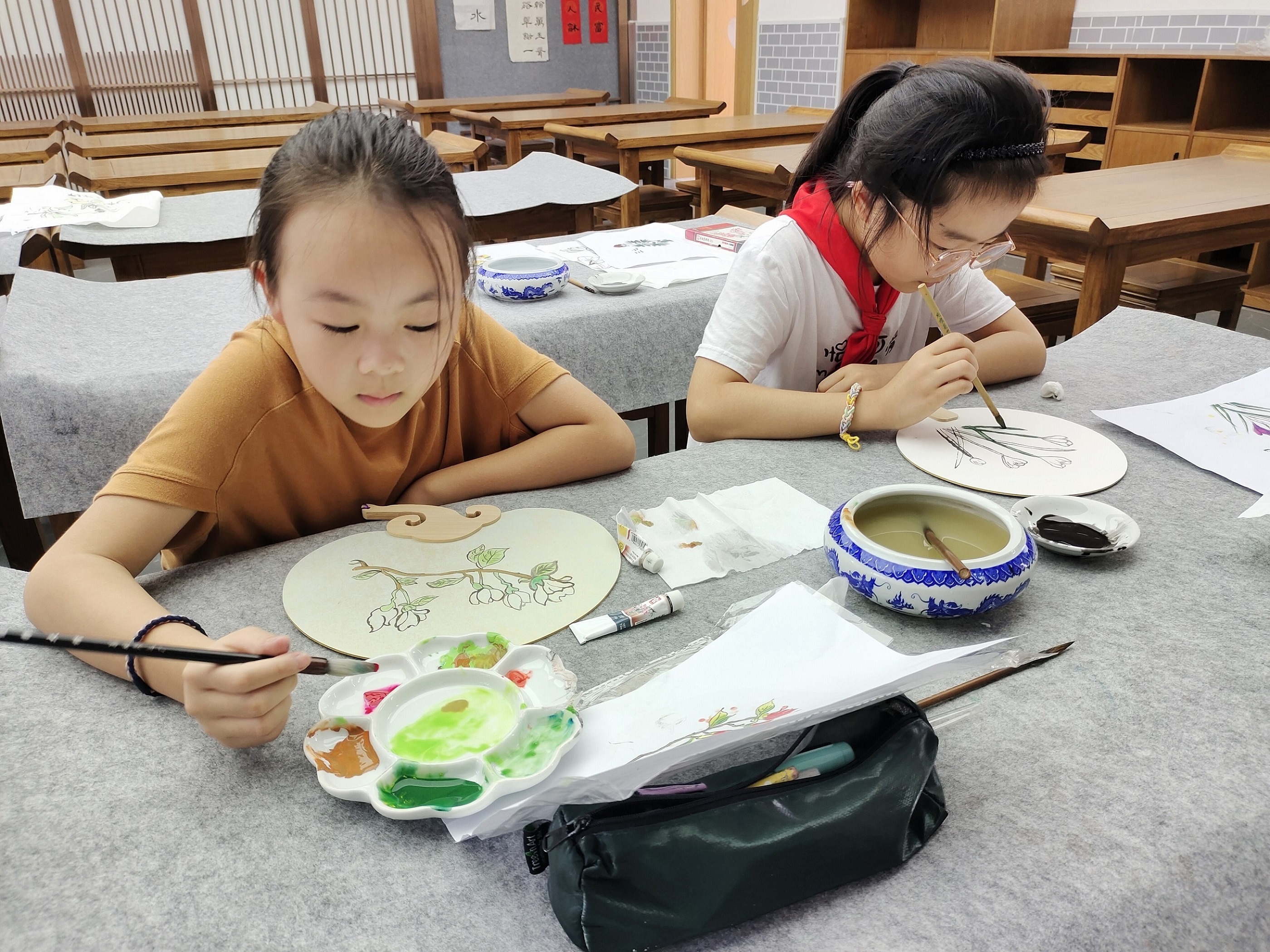 张家港市城南小学重视传统文化教育，依托“儿童问学”科学课程项目，开设系列实践课，让中华优秀传统文化活起来、立起来。图：绘制中草药团扇