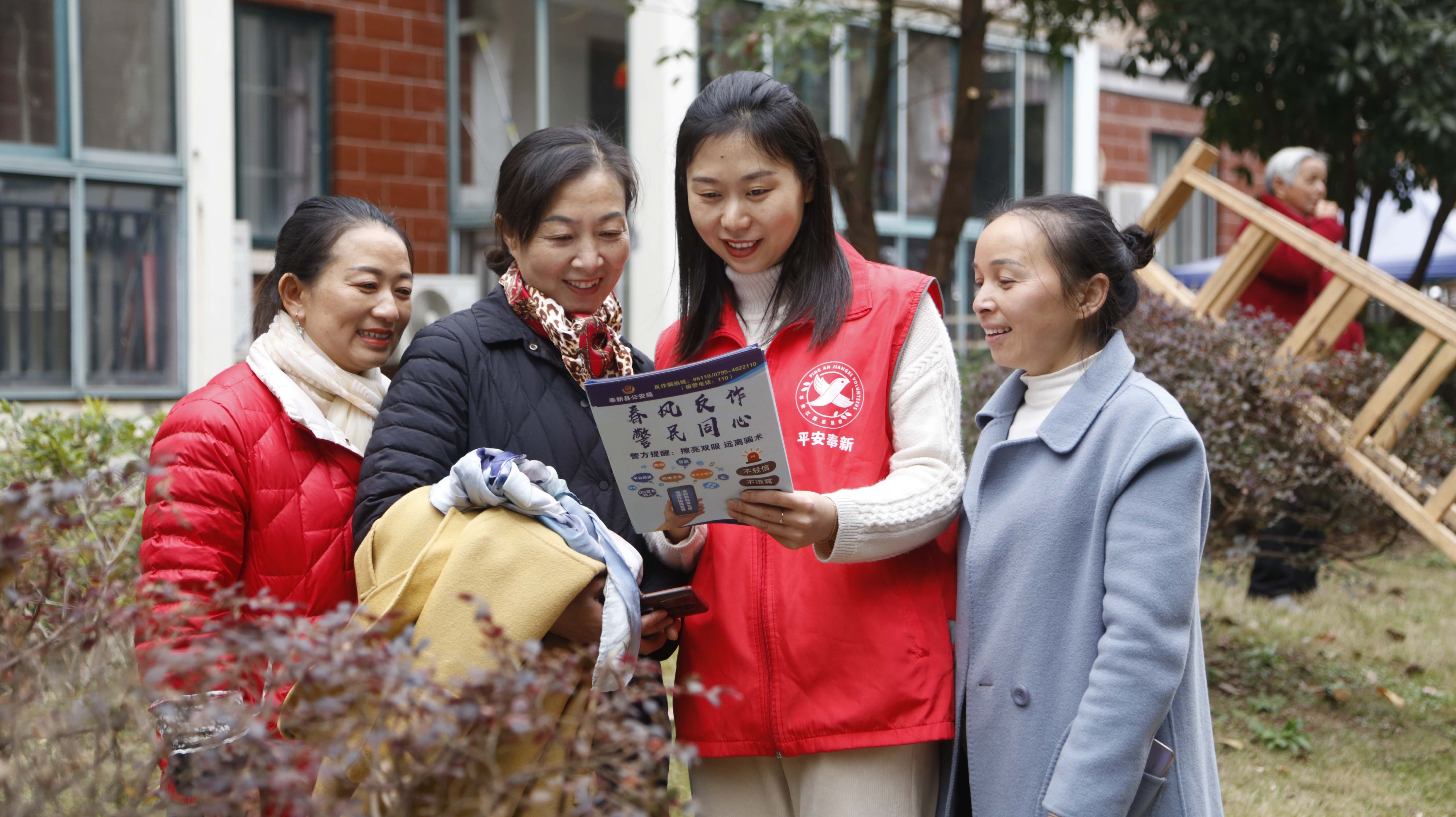 奉新县冯川镇文峰社区志愿者在向辖区居民宣传防范非法集资有关知识。（帅萍 摄）