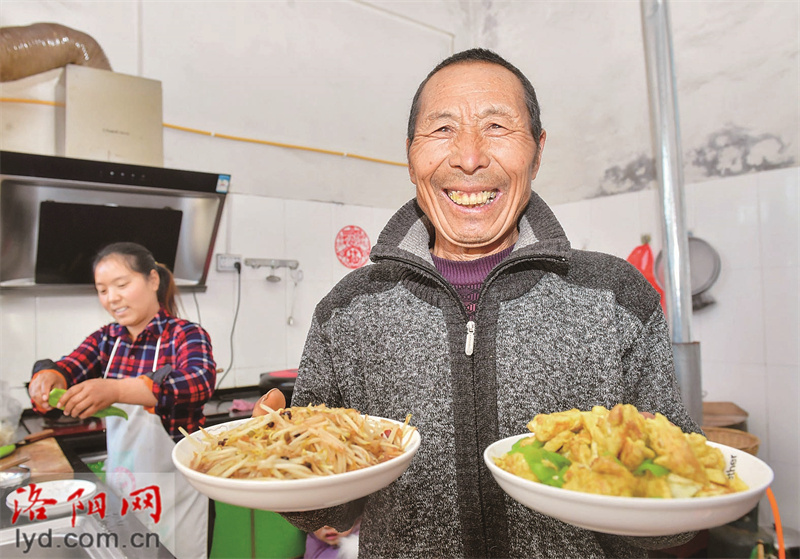 12月27日，在嵩县饭坡镇沙坡村一农家宾馆，“大厨”正在为游客端上特色农家菜。