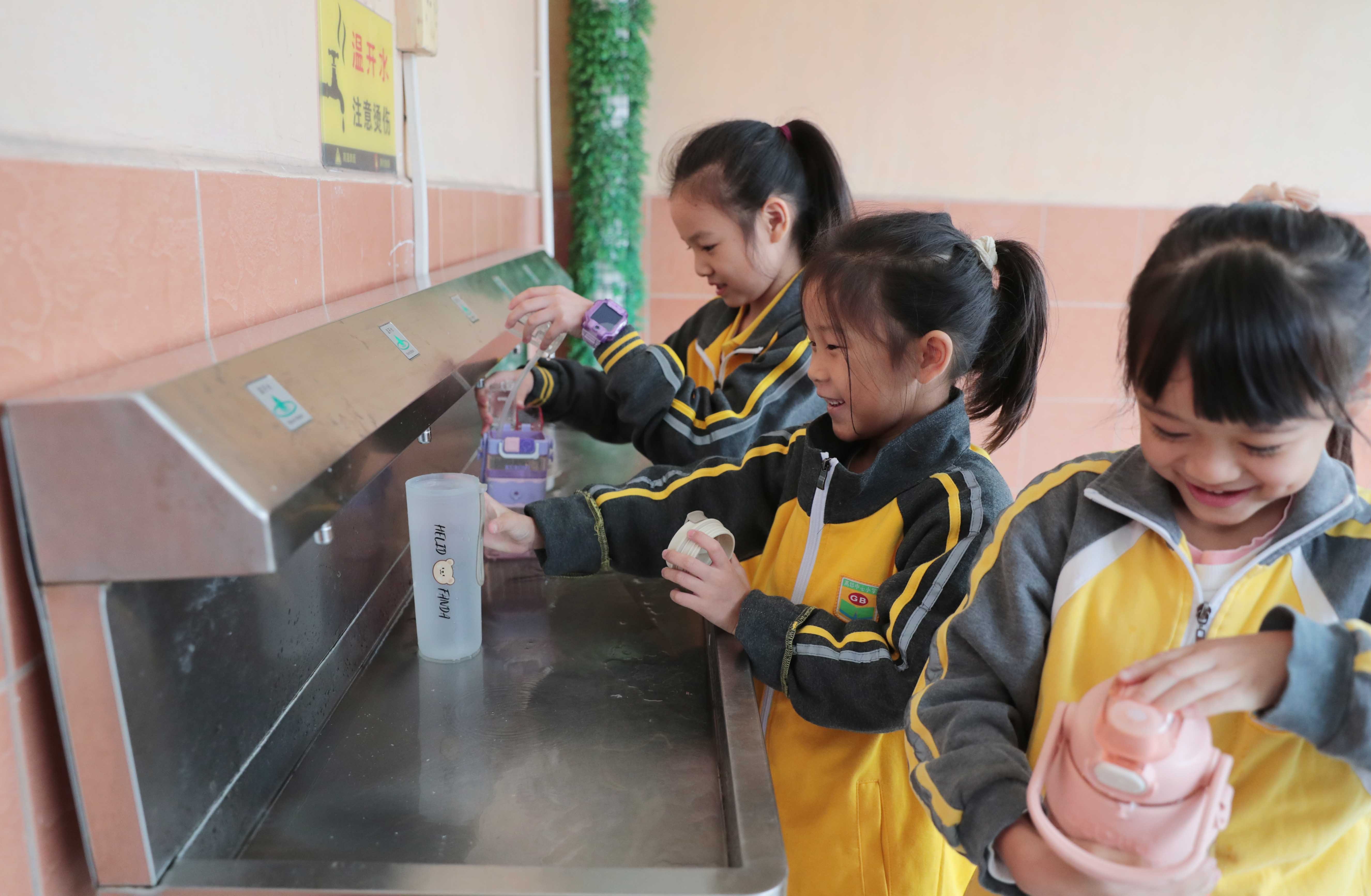 课间休息时间，接水区充满了欢声笑语。（摄影：李淦斌）