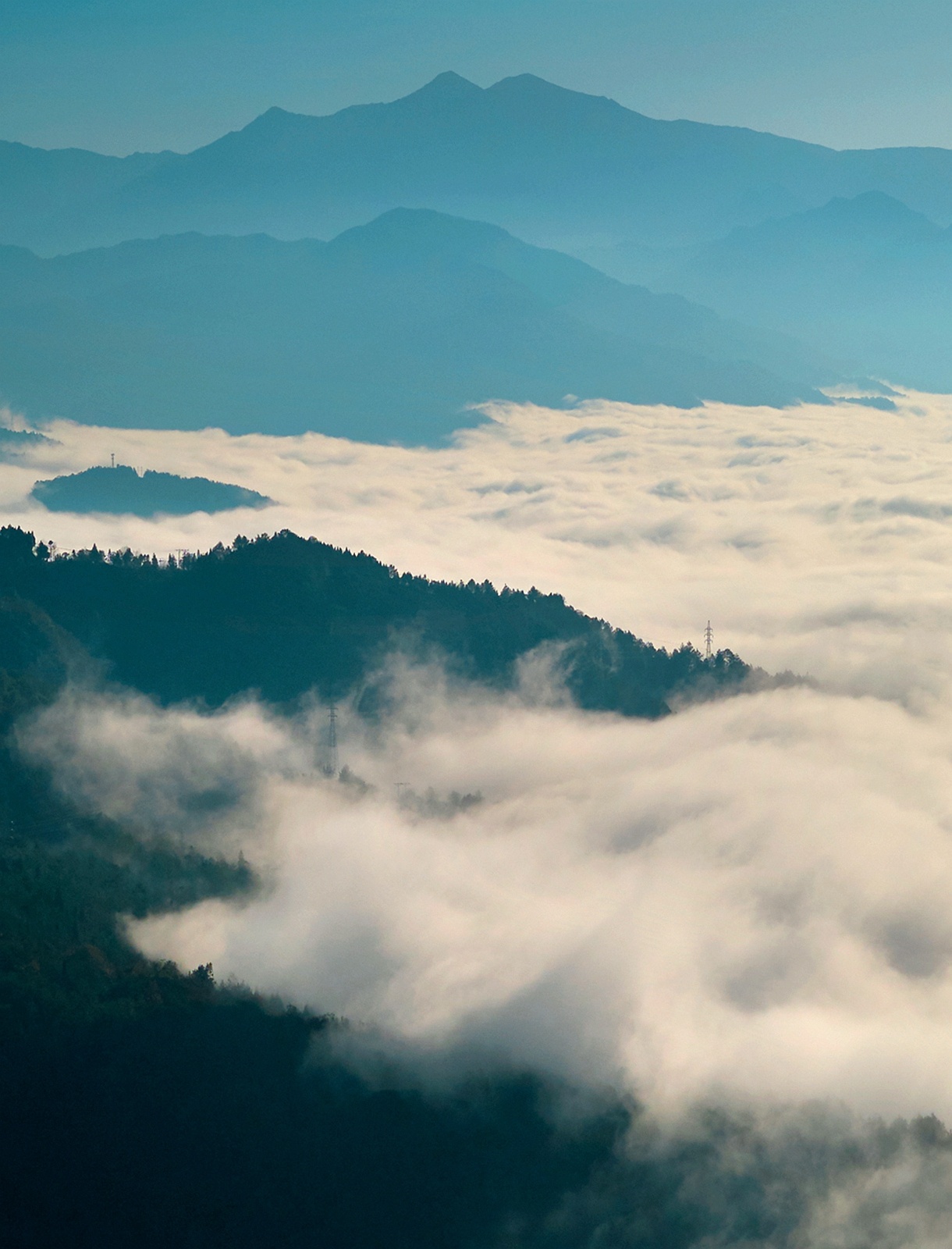 笼罩在山头的云雾，像是戴在山顶上的白色绒帽。