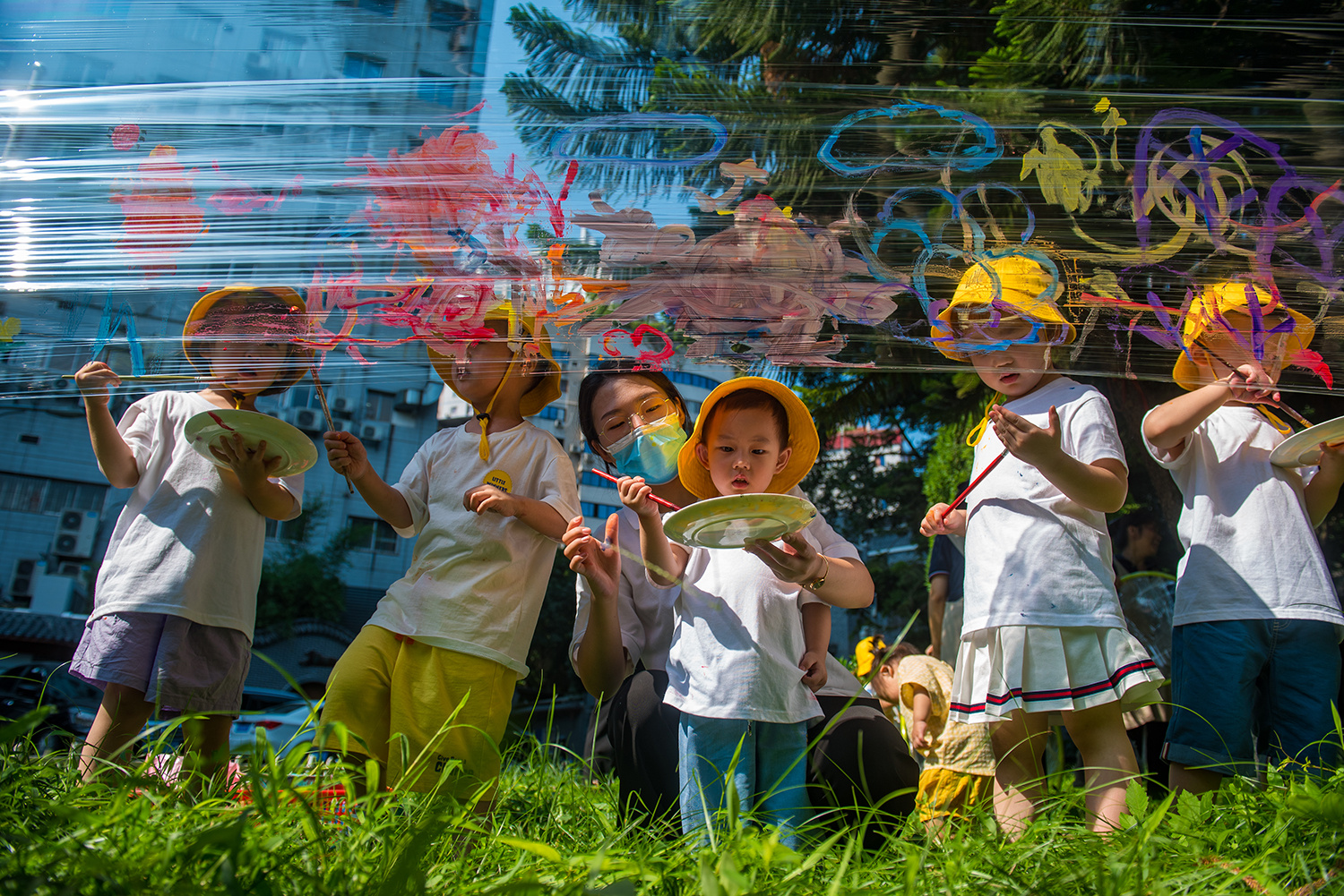 七月流火，蛙叫蝉鸣，重庆市万州中小学生暂别熟悉的校园，开启五彩斑斓、轻松愉悦的暑假生活。草坪上，萌娃随心涂画，用灿烂的色彩描绘有趣的童年。记者 侯本艳 摄